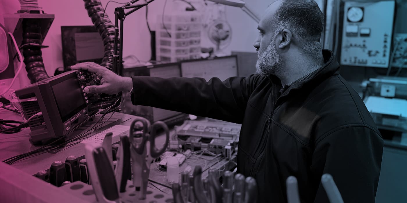 Precision Electronics technician working at an electronics test bench