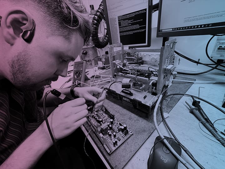 Technician soldering an industrial electronic circuit board